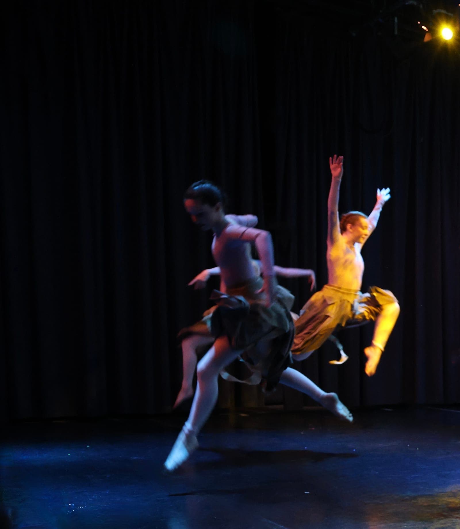 Contemporary dancers leaping across the stage