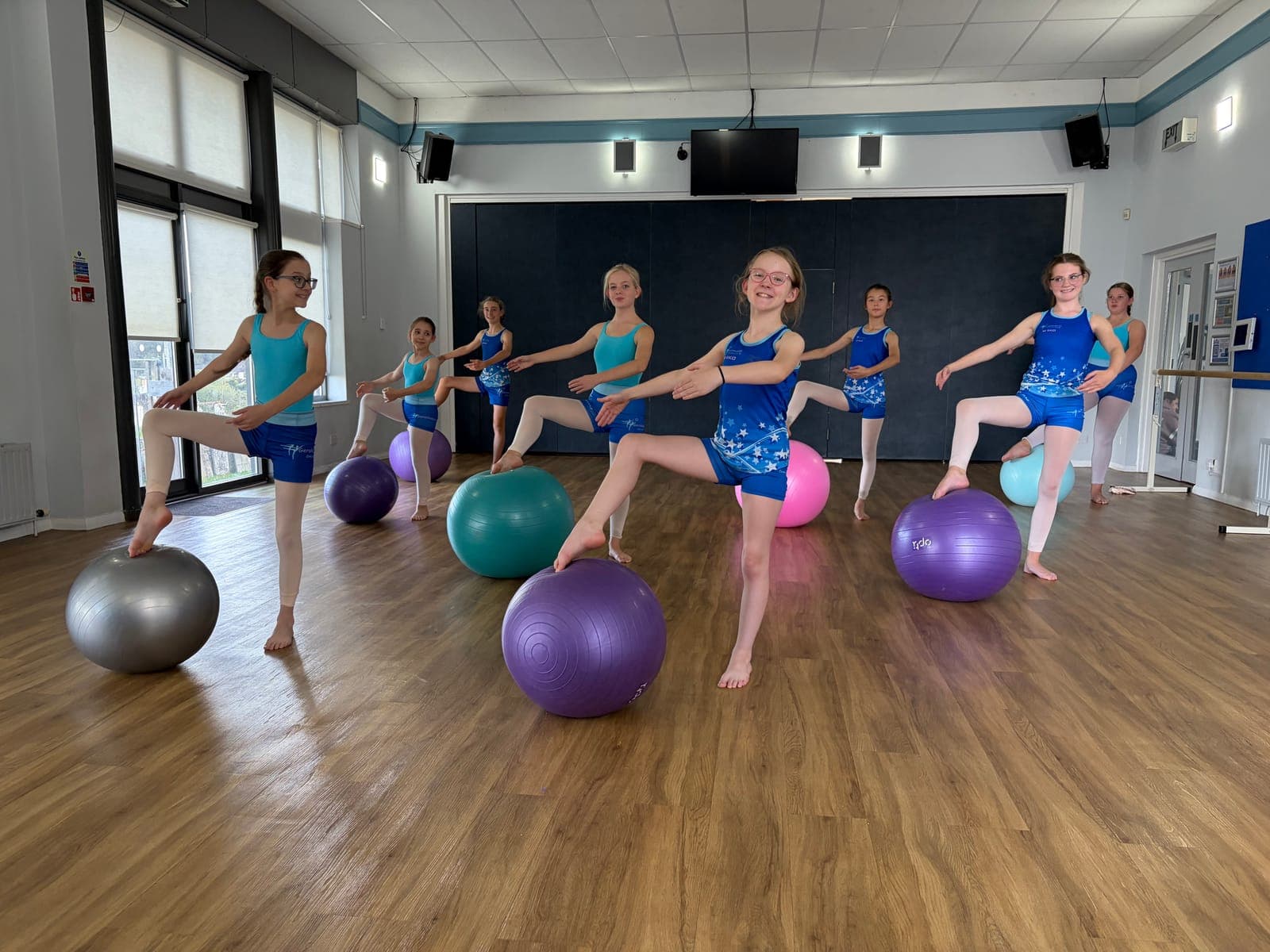 Students balancing on fitness balls in a Progressing Ballet Technique class