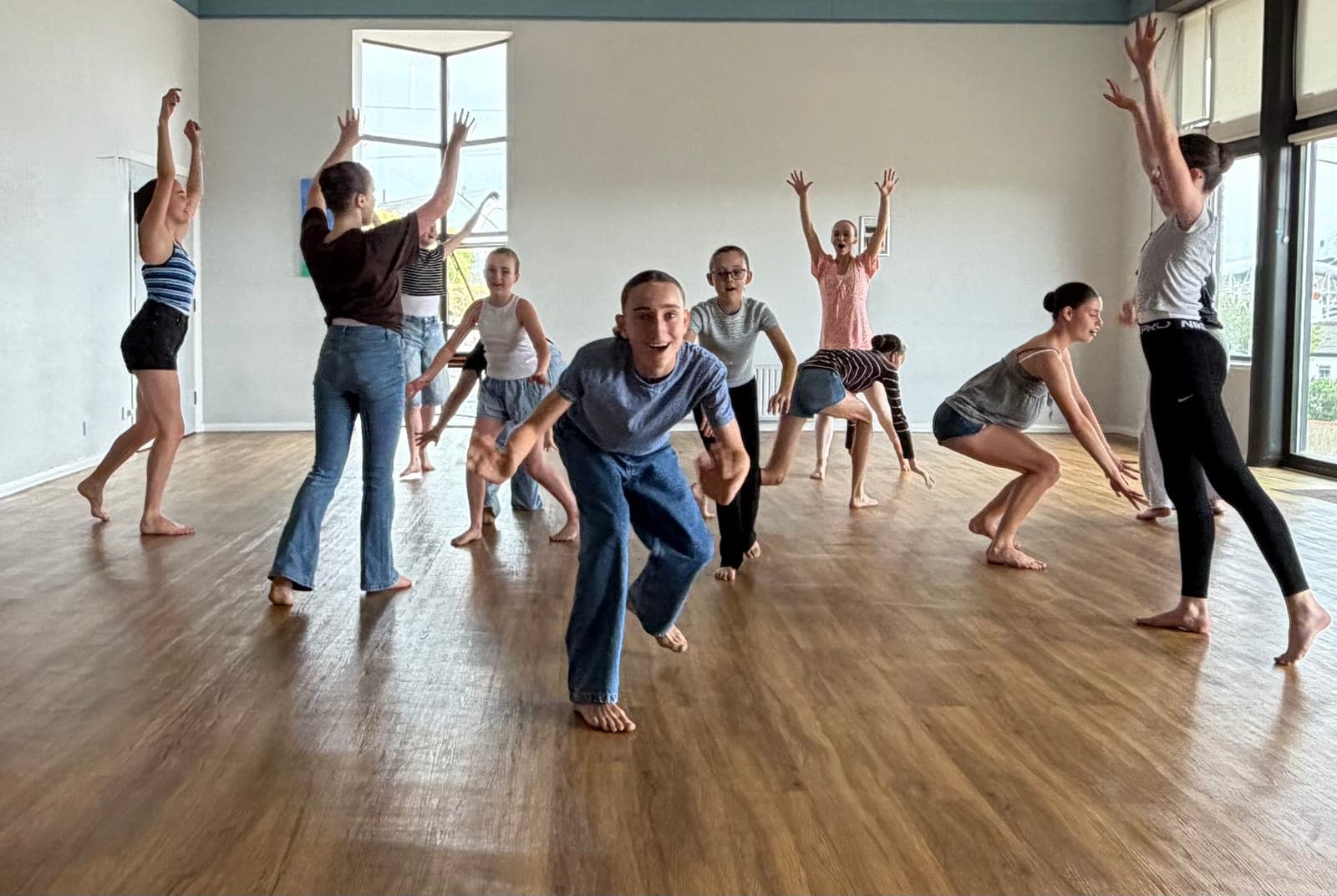 Students lunging forward with big smiles in a studio workshop